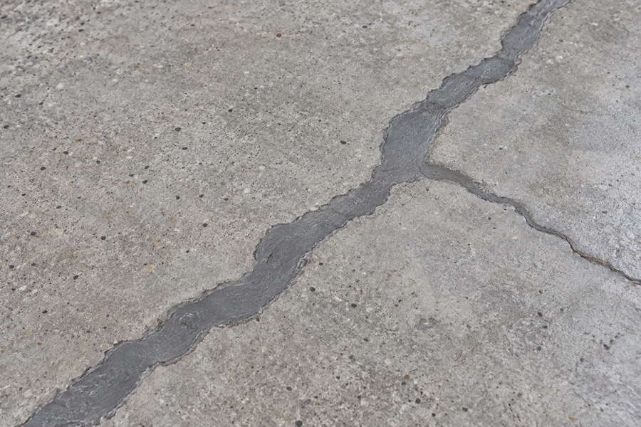 Large branching concrete crack filled flush with gray repair material